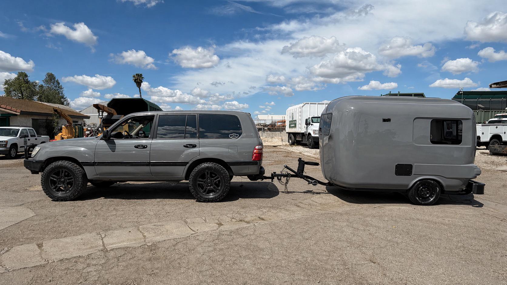 灰色のSUVとキャンピングトレーラー